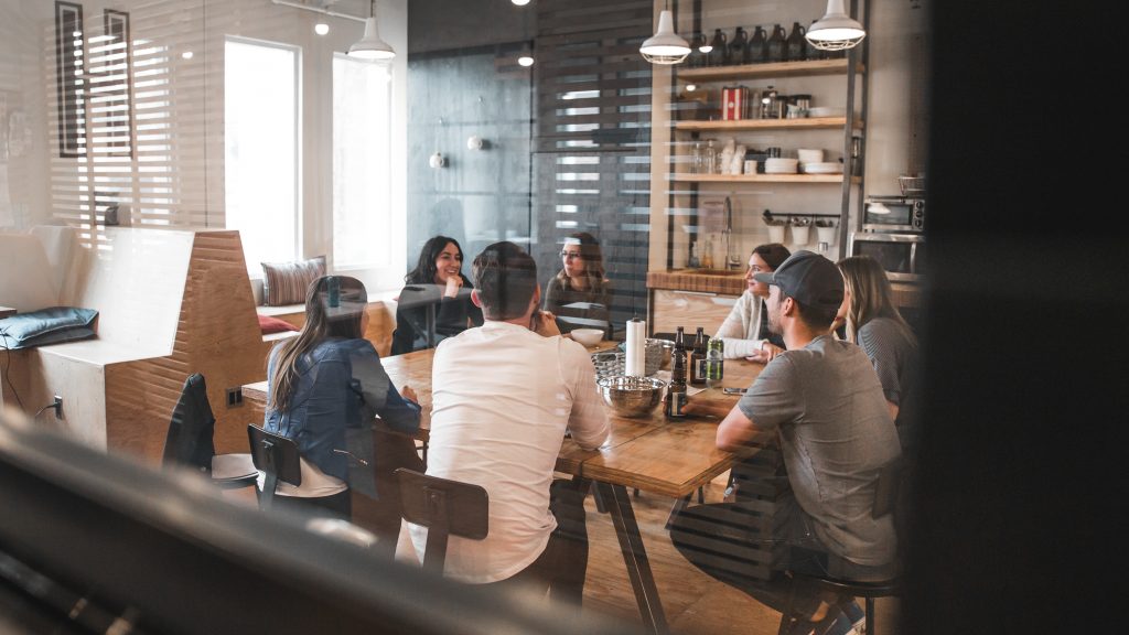 A team sitting around a table focused on one speaker - How to become an apprentice