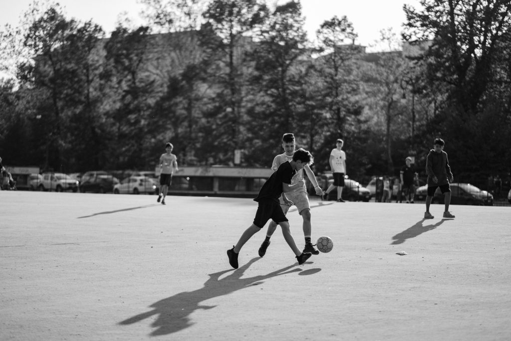 black white children playing football park activity fun