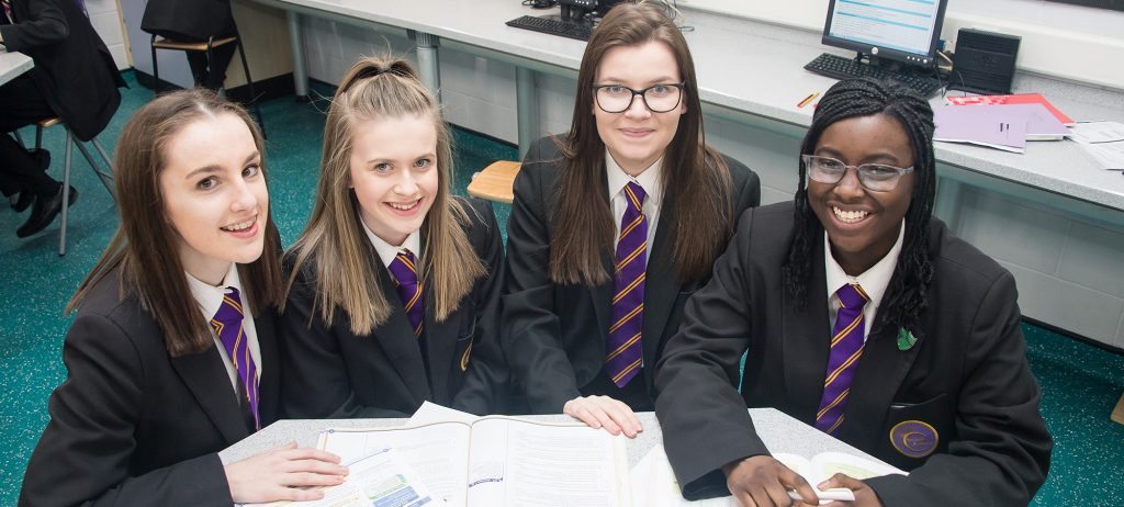 Four secondary students sitting together in Walsall Academy uniform