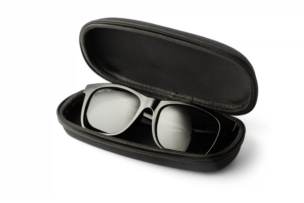 A Black sunglasses hard case that is open with a pair of Ray-Ban style black plain sunglasses inside.