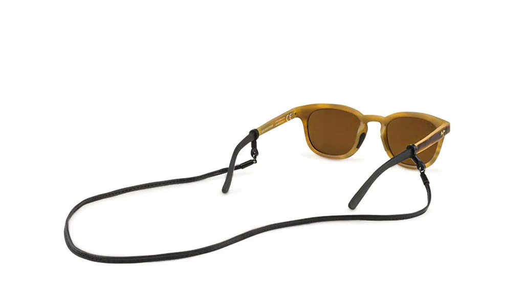 Some Gold sunglasses that have a black cord attached to them.